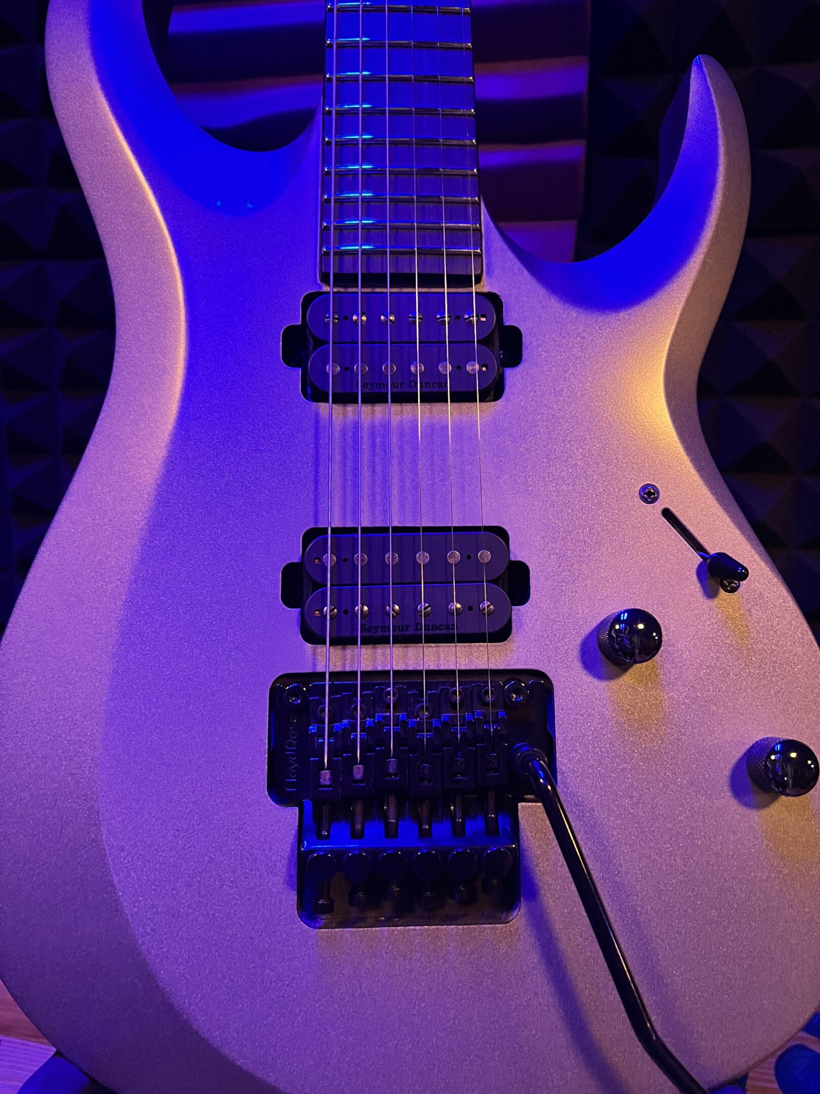 Electric guitar with purple lighting.