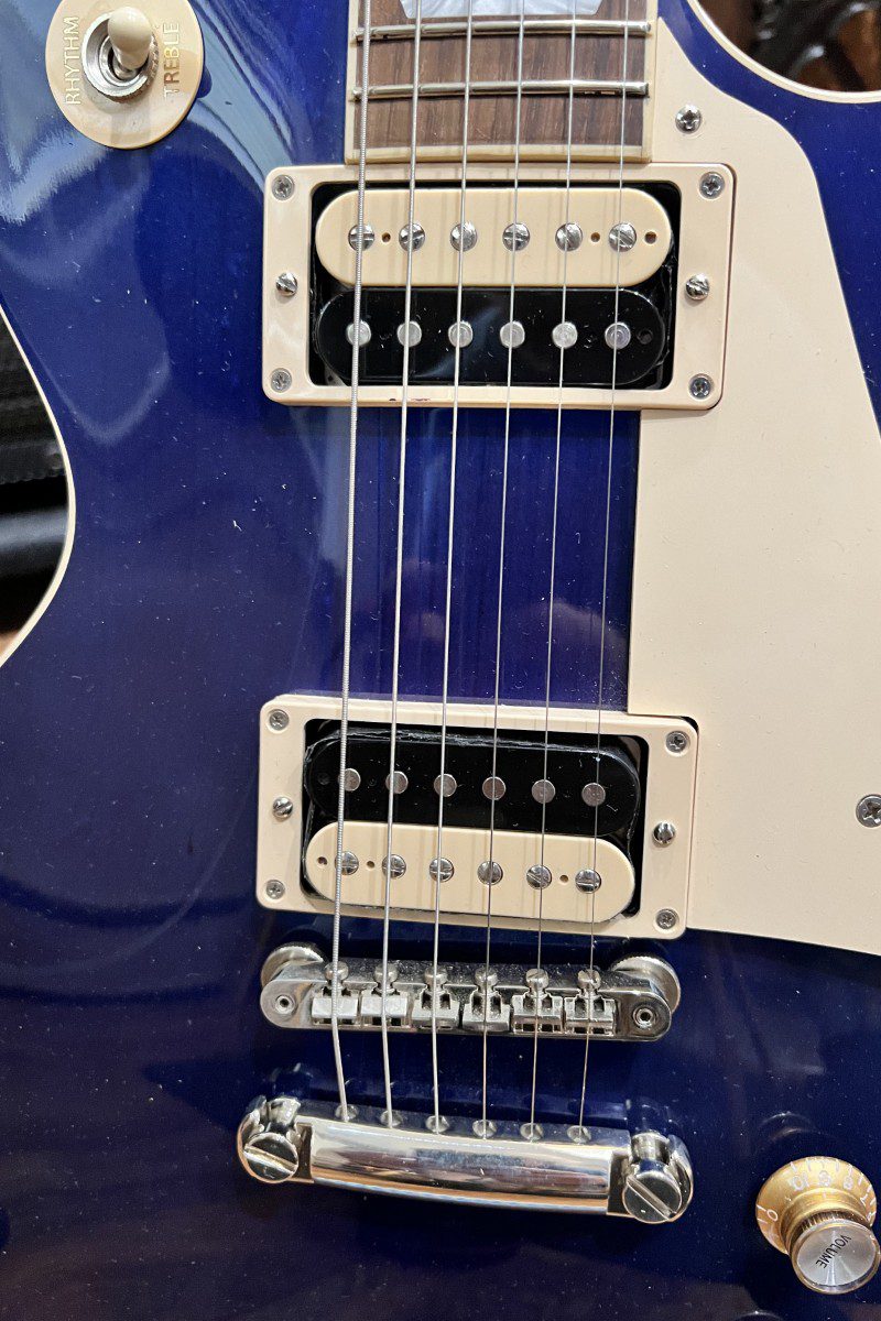 Close-up of electric guitar pickups and strings.