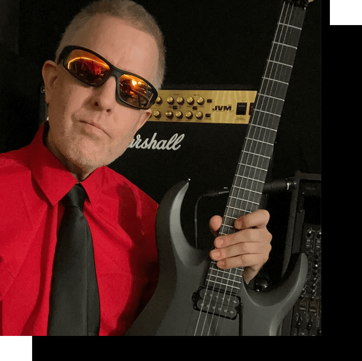 Man in red shirt holding electric guitar.