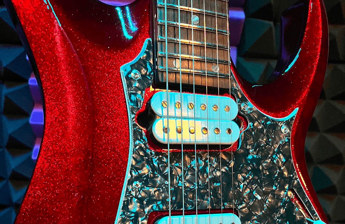 Red electric guitar with illuminated strings.