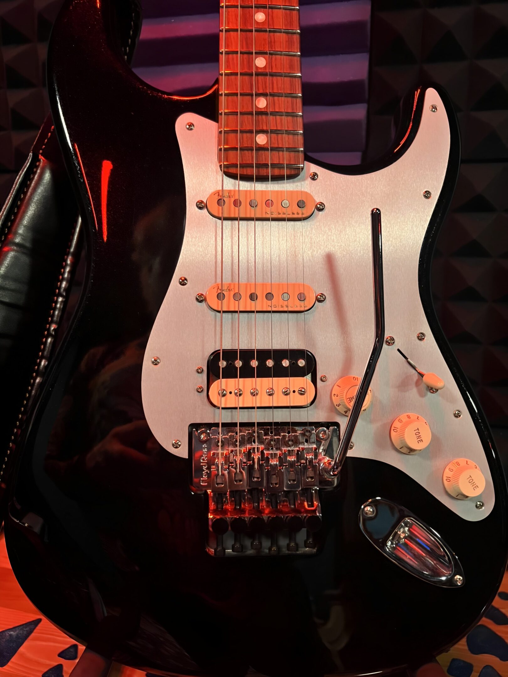 Black electric guitar with white pickguard.