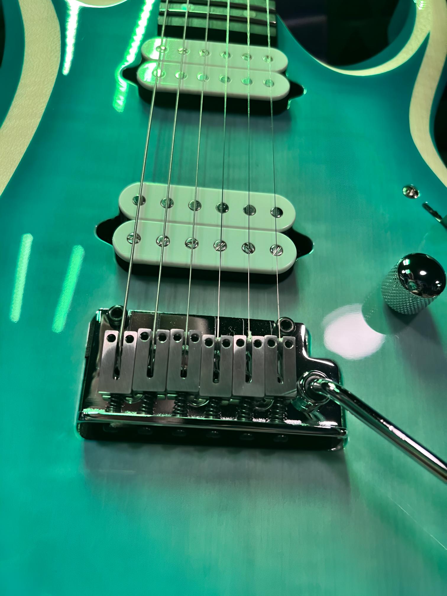 Electric guitar with teal body and strings.