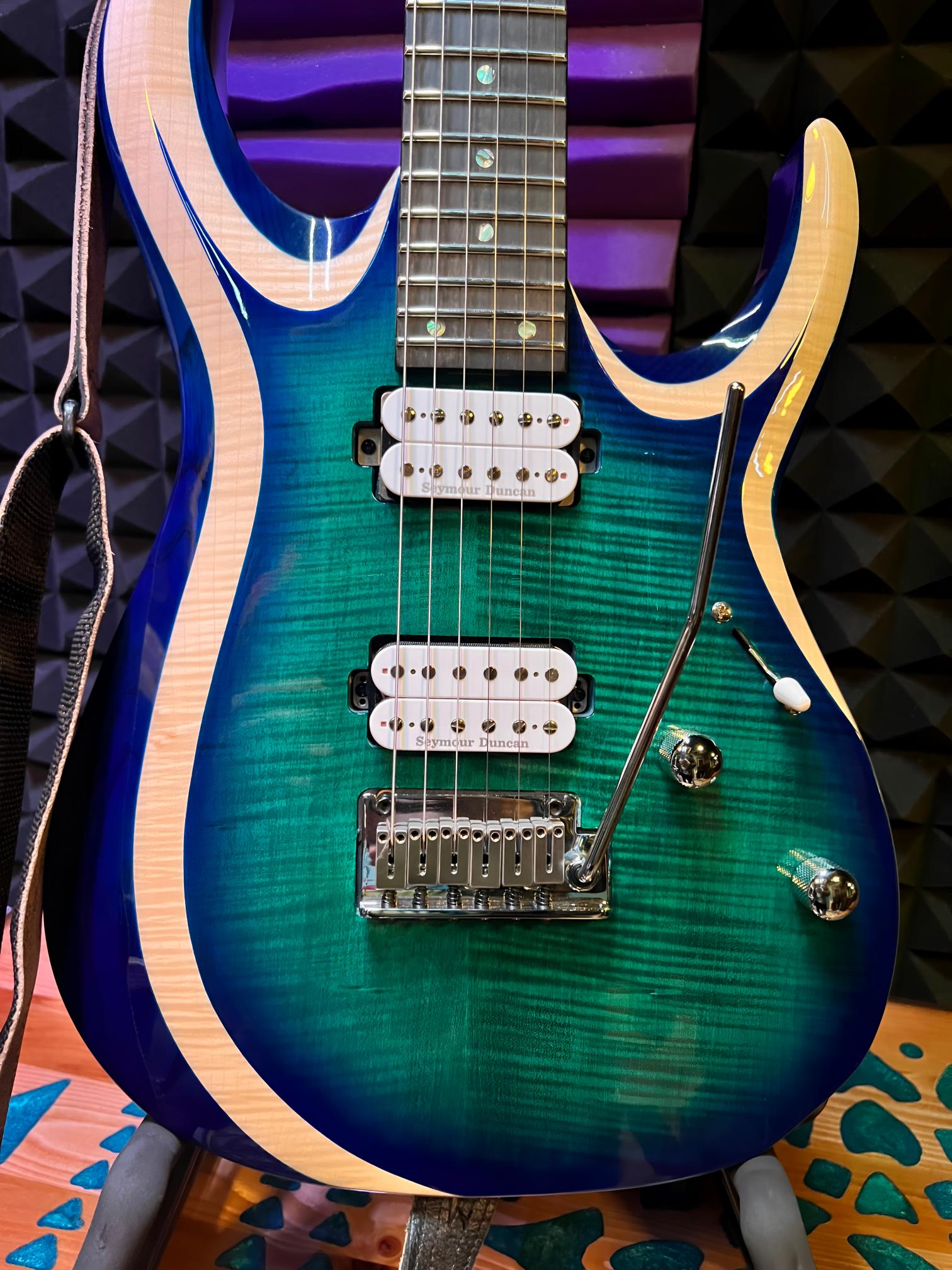 Electric guitar with blue-green gradient finish.