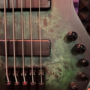Electric bass guitar with green wood finish.
