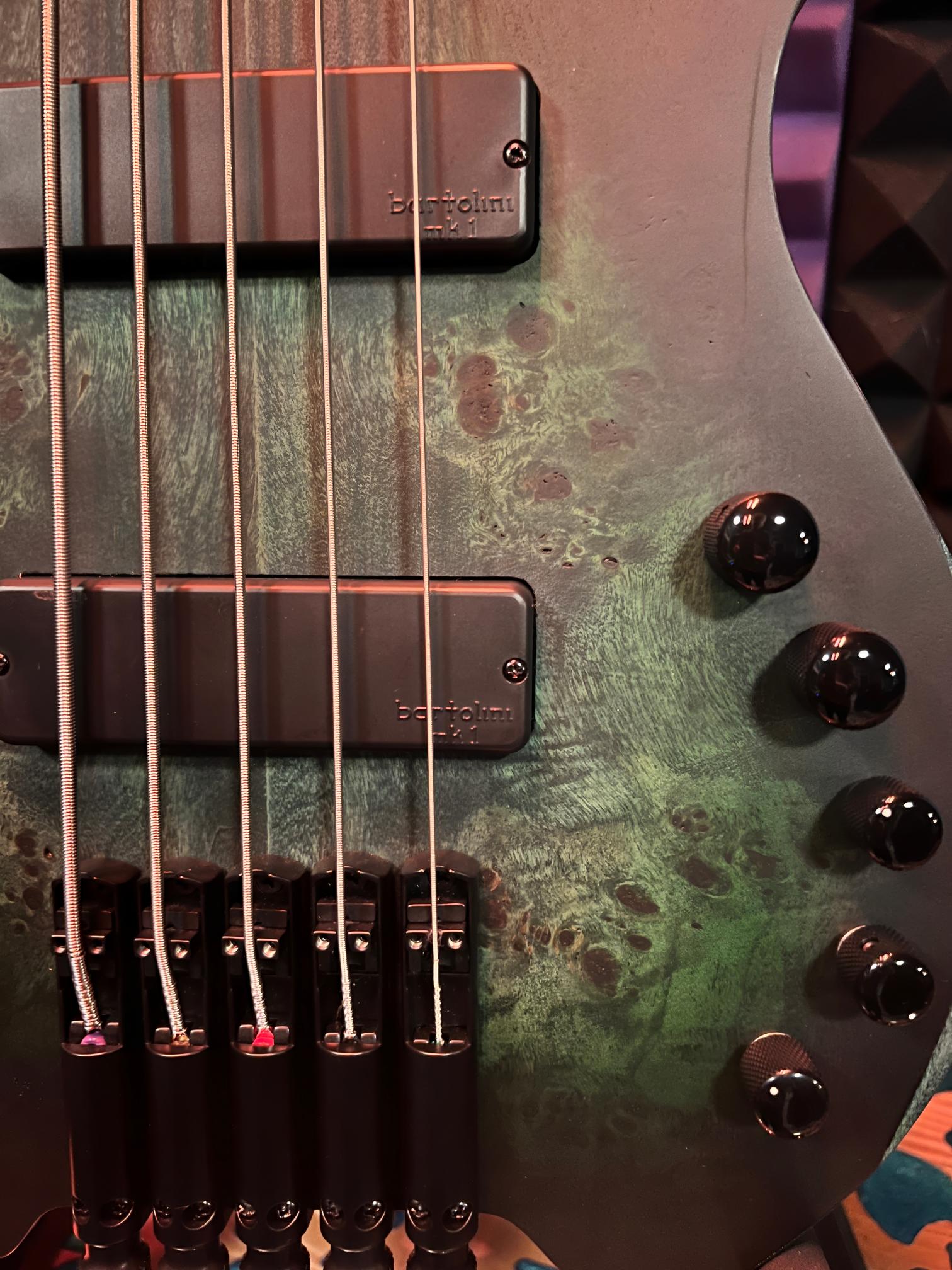 Electric bass guitar with green wood finish.